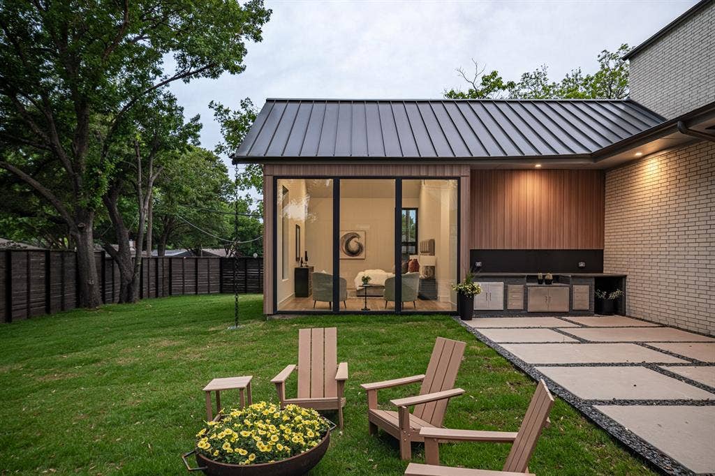 4103 Saranac Drive, Dallas, TX 75220 A built-in BBQ makes entertaining effortless while expansive windows overlook the beautifully landscaped backyard, creating a visual connection between the primary suite and outdoor living spaces.