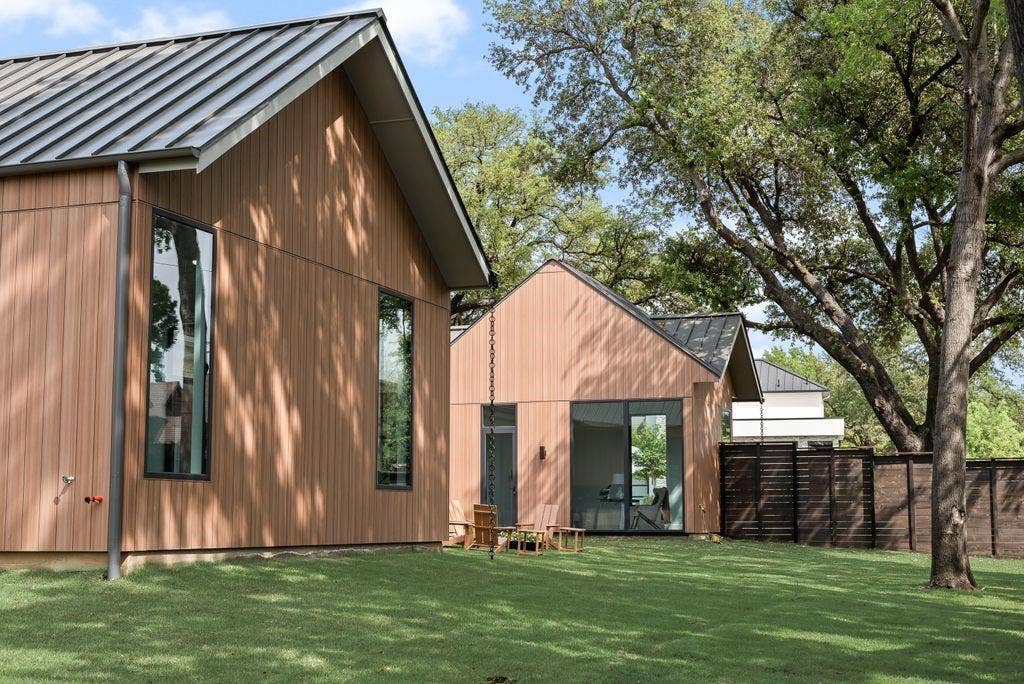 4103 Saranac Drive, Dallas, TX 75220 Board and batten siding in natural tones complements the wood-stained fence and mature trees, creating a warm and inviting exterior.