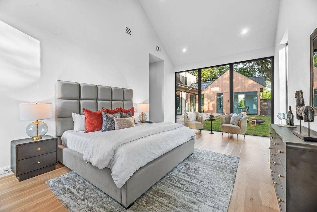 4103 Saranac Drive, Dallas, TX 75220 The primary suite offers a light-filled retreat with vaulted ceilings and expansive glass that draws in the natural surroundings, creating a calm and restorative atmosphere.