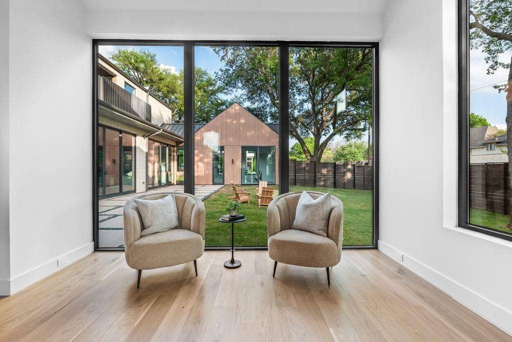 4103 Saranac Drive, Dallas, TX 75220 Floor-to-ceiling windows frame the backyard, creating a peaceful sitting area with uninterrupted views of the outdoor setting.