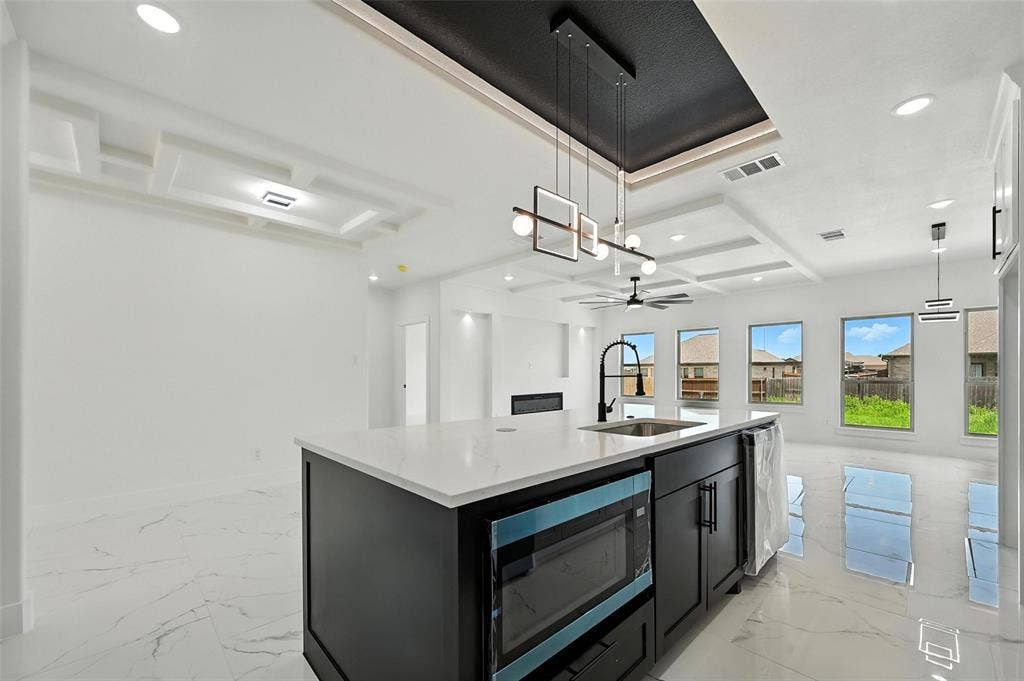 Kitchen island with a built-in microwave, white countertop, and integrated sink