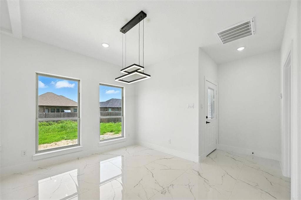 White walls, contemporary light fixture, recessed lighting, double windows, and white tile flooring with gray veining