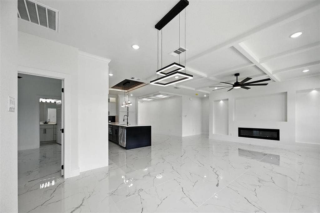 Polished tile flooring, coffered ceiling, linear electric fireplace, modern ceiling fan, and contemporary pendant lighting