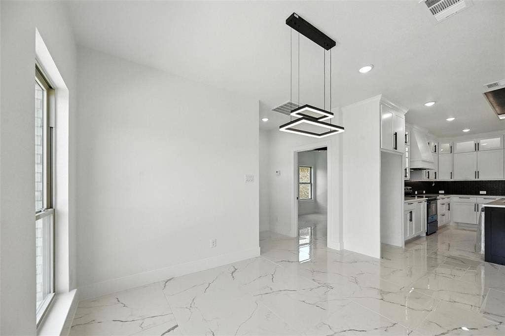 Open concept living space featuring a modern linear chandelier, recessed lighting, and white walls