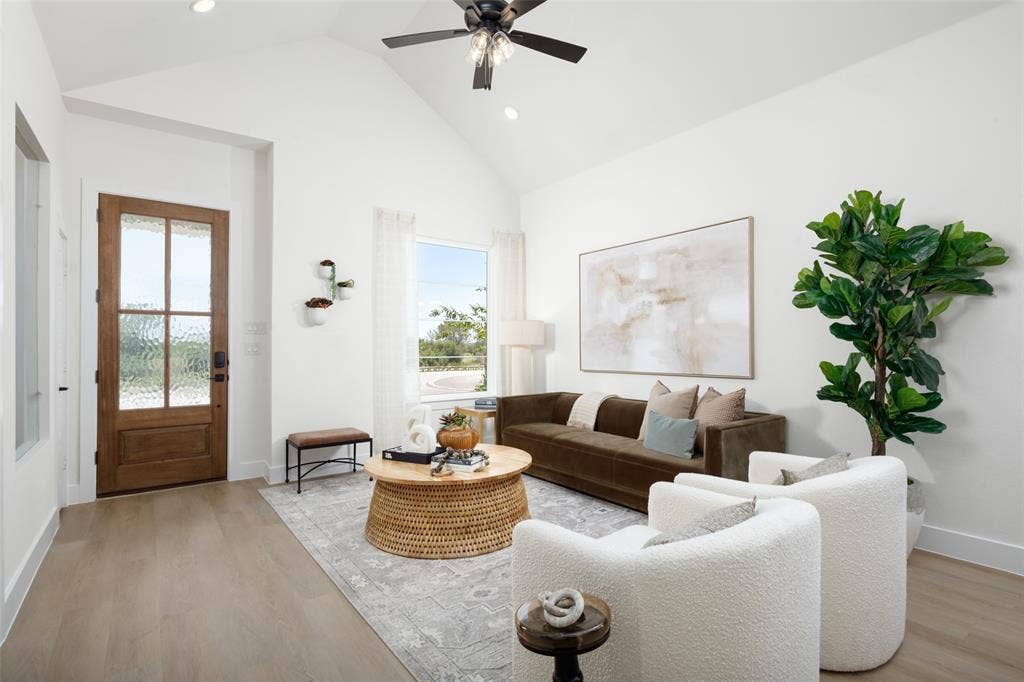Vaulted ceiling, wood-finish flooring, recessed lighting, wood-paneled entry door with frosted glass, and a ceiling fan