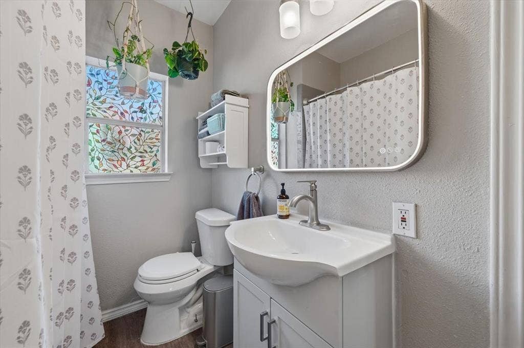 809 W Bridge Street, Weatherford, TX 76086 Wall-mounted vanity with integrated sink, brushed nickel faucet, and under-sink storage