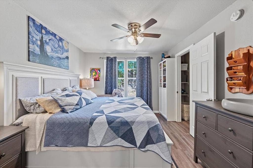 809 W Bridge Street, Weatherford, TX 76086 Wood-finish flooring, ceiling fan with integrated lighting, window with light-filtering curtains, and a built-in closet with double bifold doors