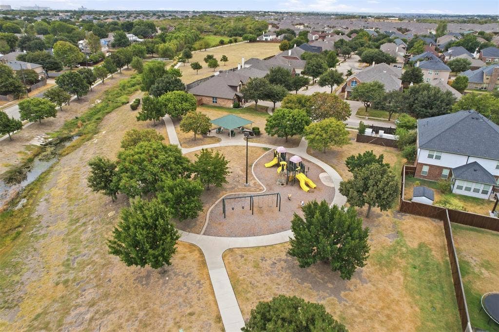 9005 Fescue Drive, Fort Worth, TX 76179 Community park with recreational equipment, mature trees, paved pathways, and a covered pavilion