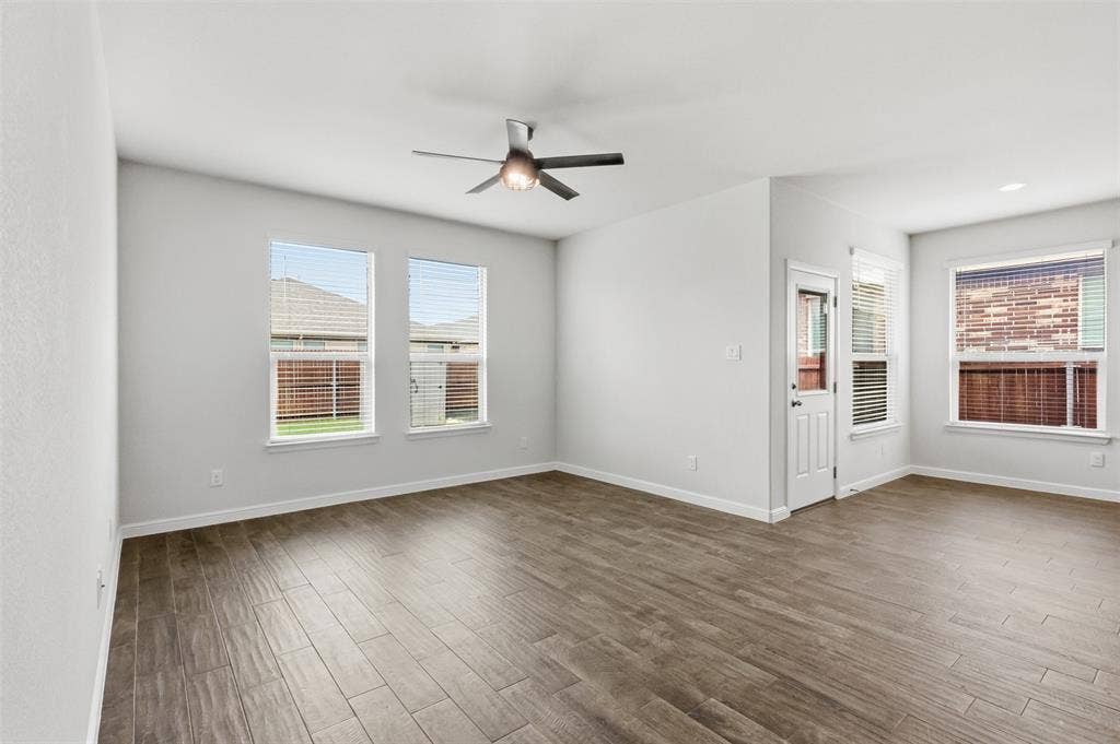 9005 Fescue Drive, Fort Worth, TX 76179 Spacious room featuring Tile flooring, multiple windows with blinds, a ceiling fan with integrated lighting, and a white paneled door