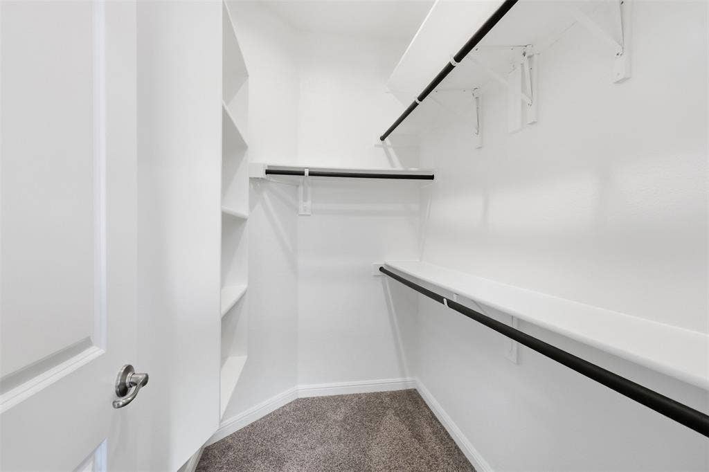 9005 Fescue Drive, Fort Worth, TX 76179 Walk-in closet featuring built-in shelving, white walls, and carpeting
