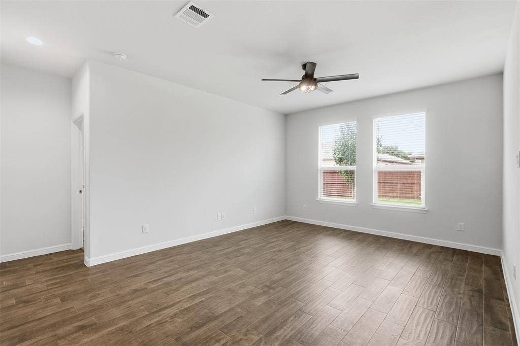 9005 Fescue Drive, Fort Worth, TX 76179 Spacious room featuring wood-finish flooring, white walls, and a ceiling fan with integrated lighting