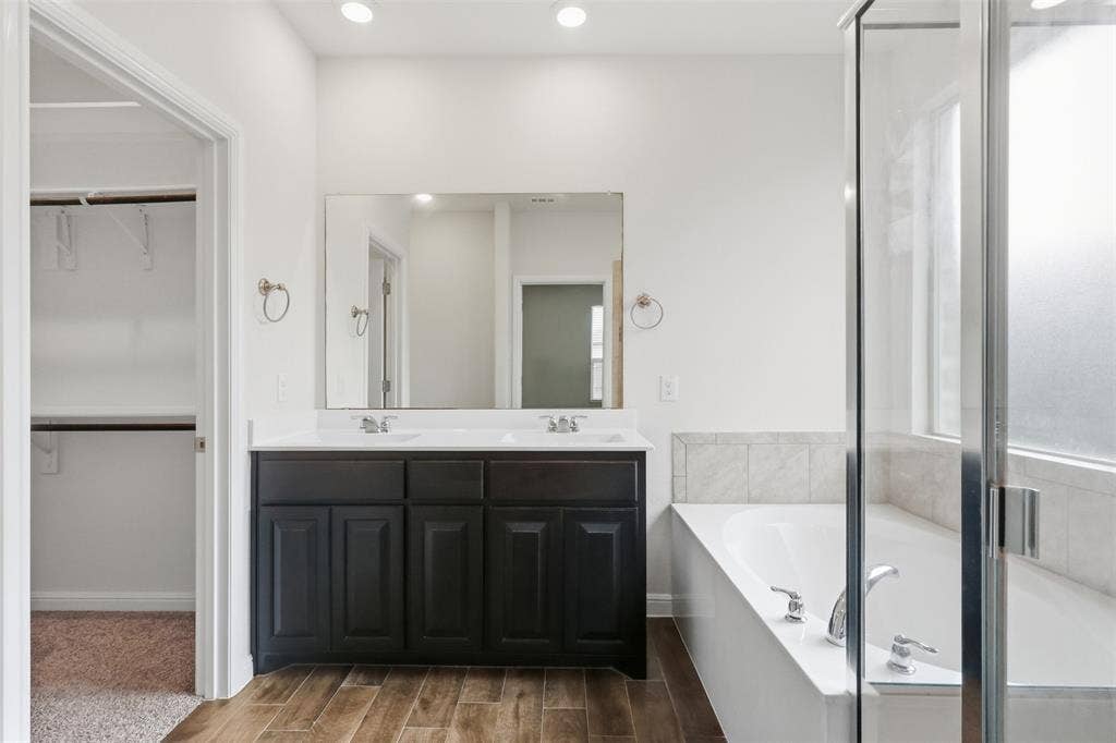 9005 Fescue Drive, Fort Worth, TX 76179 Dual vanity with dark cabinetry and white countertops