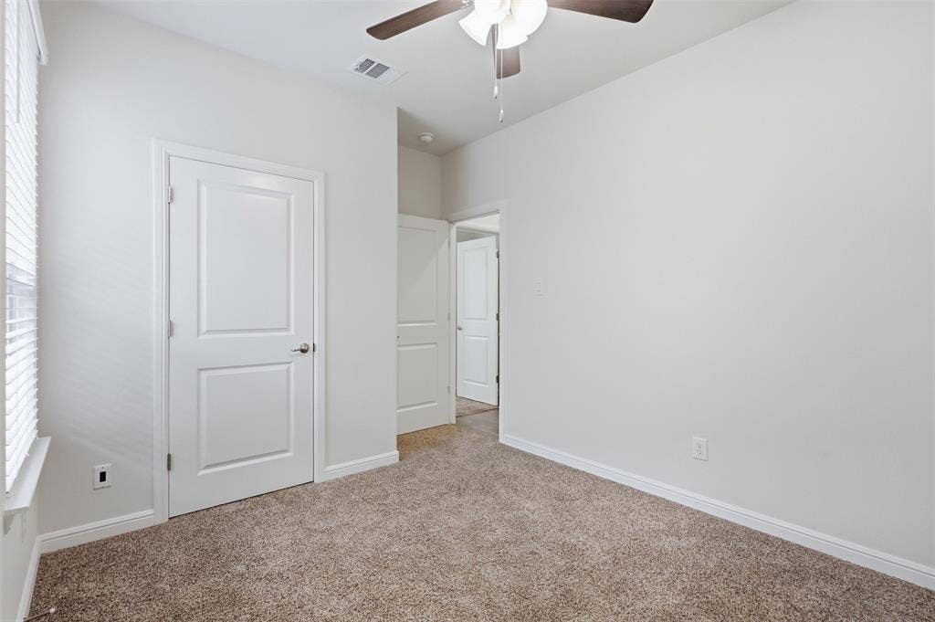9005 Fescue Drive, Fort Worth, TX 76179 Neutral wall finishes, textured carpet flooring, ceiling fan with integrated lighting, and white interior doors