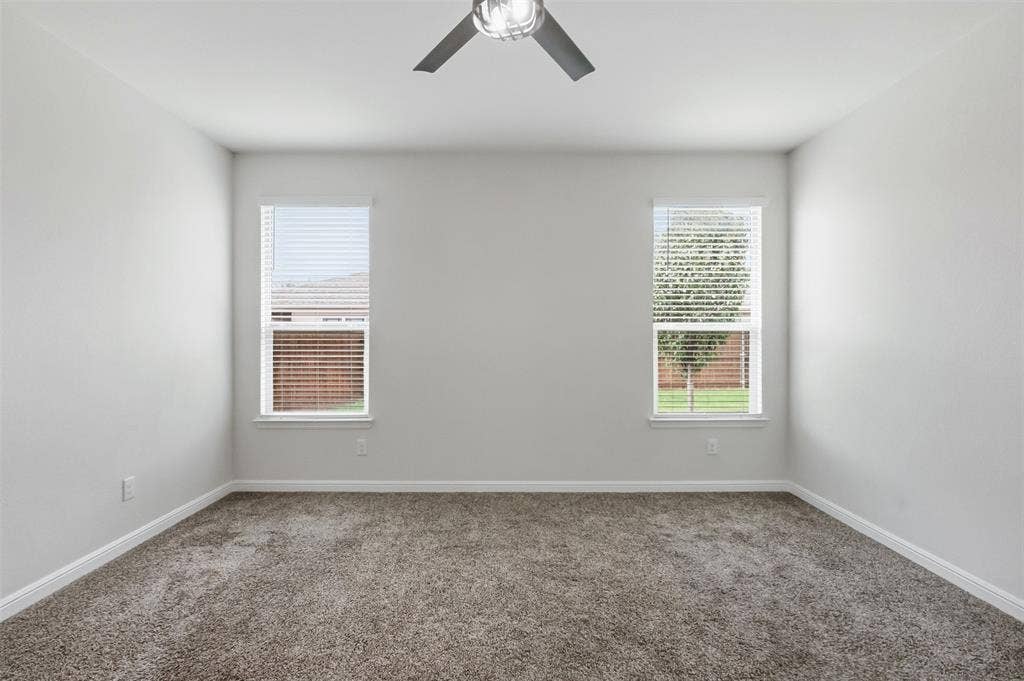 9005 Fescue Drive, Fort Worth, TX 76179 Recessed lighting, ceiling fan with brushed metal accents, two windows with blinds, and neutral carpeting