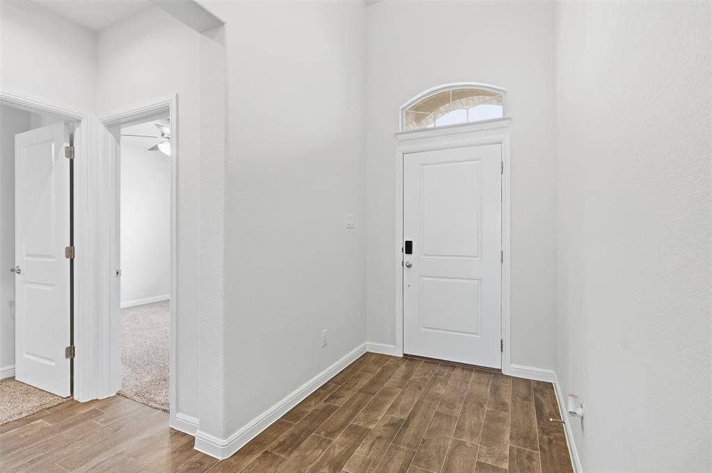 9005 Fescue Drive, Fort Worth, TX 76179 Entryway featuring Tile flooring, a white paneled door with smart lock, and an arched transom window