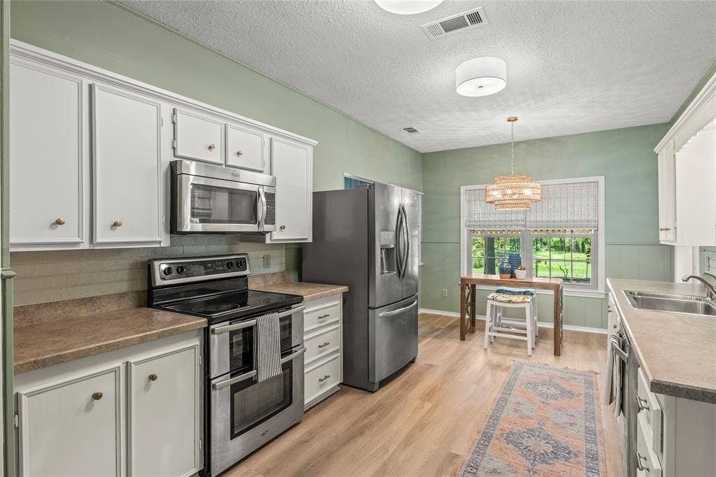 125 Harrell Street, Gun Barrel City, TX 75156 Freshly painted kitchen features new stainless steel appliances, sink, fixtures, and luxury vinyl plank floor.