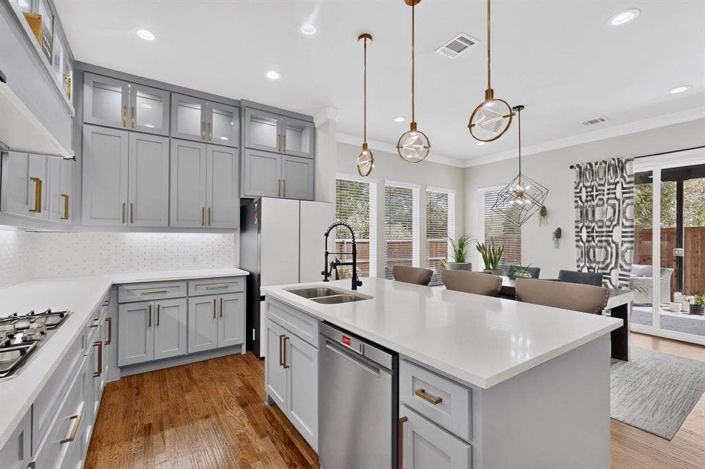 518 Crete Street, Dallas, TX 75203 Spacious kitchen featuring an island, light gray cabinetry, white countertops, stainless steel appliances, and wood-finish flooring
