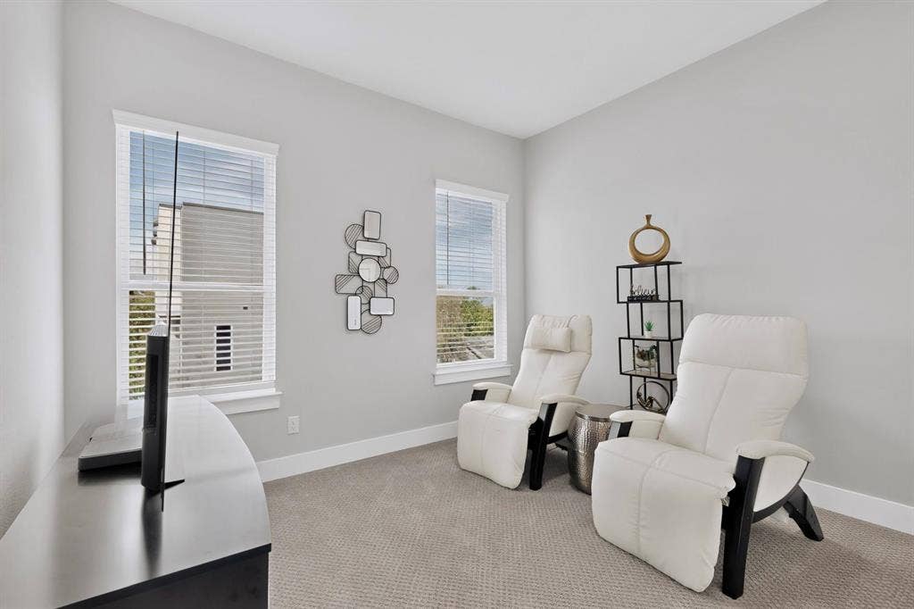 518 Crete Street, Dallas, TX 75203 Light gray walls with white trim, two windows with blinds, and light gray carpeting