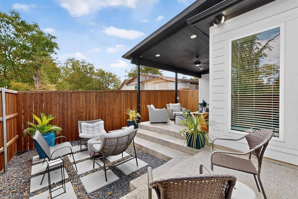 518 Crete Street, Dallas, TX 75203 Private outdoor patio space featuring a wood fence, concrete steps, and a covered area with a ceiling fan