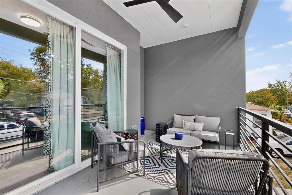 518 Crete Street, Dallas, TX 75203 Outdoor balcony featuring a ceiling fan, sliding glass doors, white trim, and a black metal railing