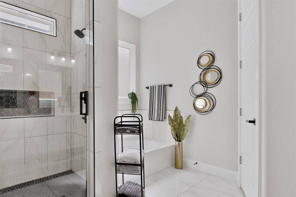 518 Crete Street, Dallas, TX 75203 Glass-enclosed shower with a matte black shower head, built-in tiled niche, and dark pebble floor