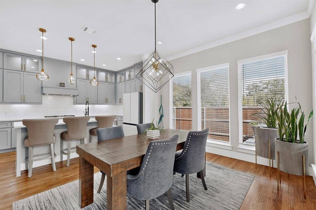 518 Crete Street, Dallas, TX 75203 Well-appointed kitchen featuring light gray cabinetry, a white subway tile backsplash, and three pendant lights over a spacious island