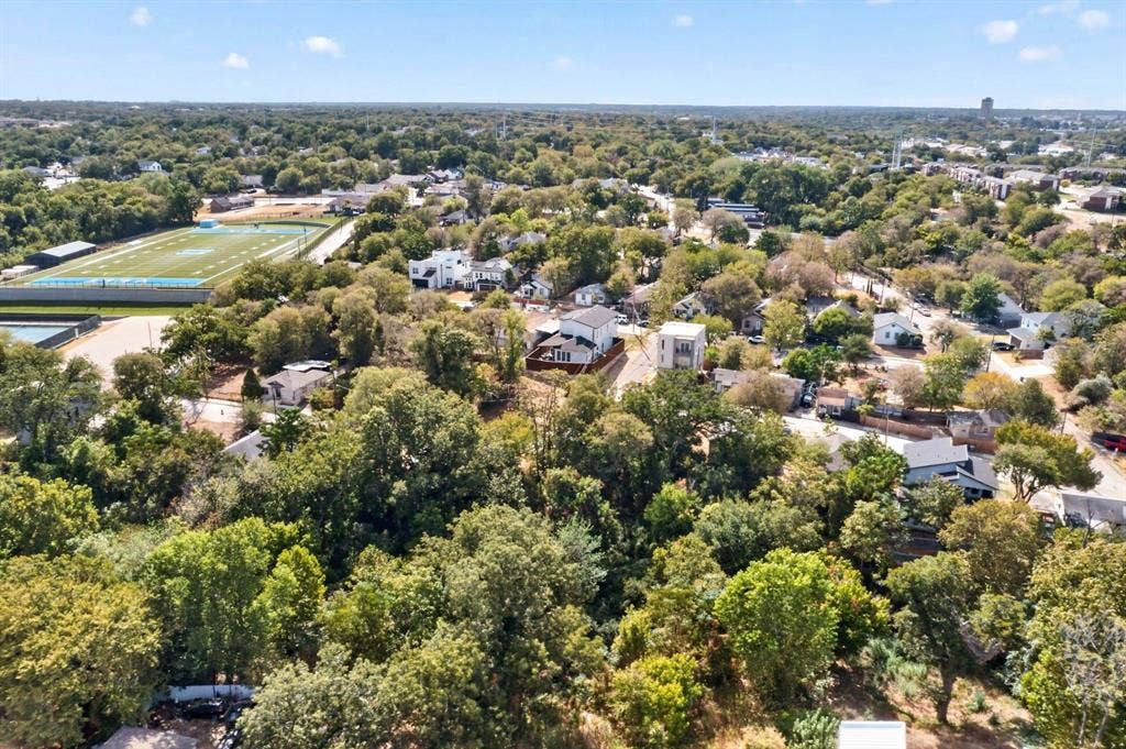 518 Crete Street, Dallas, TX 75203 Aerial perspective showcasing a residential area with extensive tree coverage and a distant athletic field