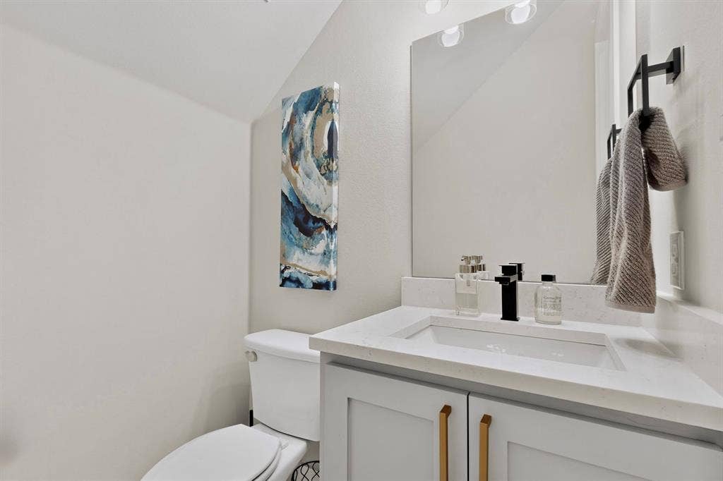 518 Crete Street, Dallas, TX 75203 Vanity with white countertop, integrated rectangular sink, matte black faucet, and light gray cabinetry with gold-toned hardware