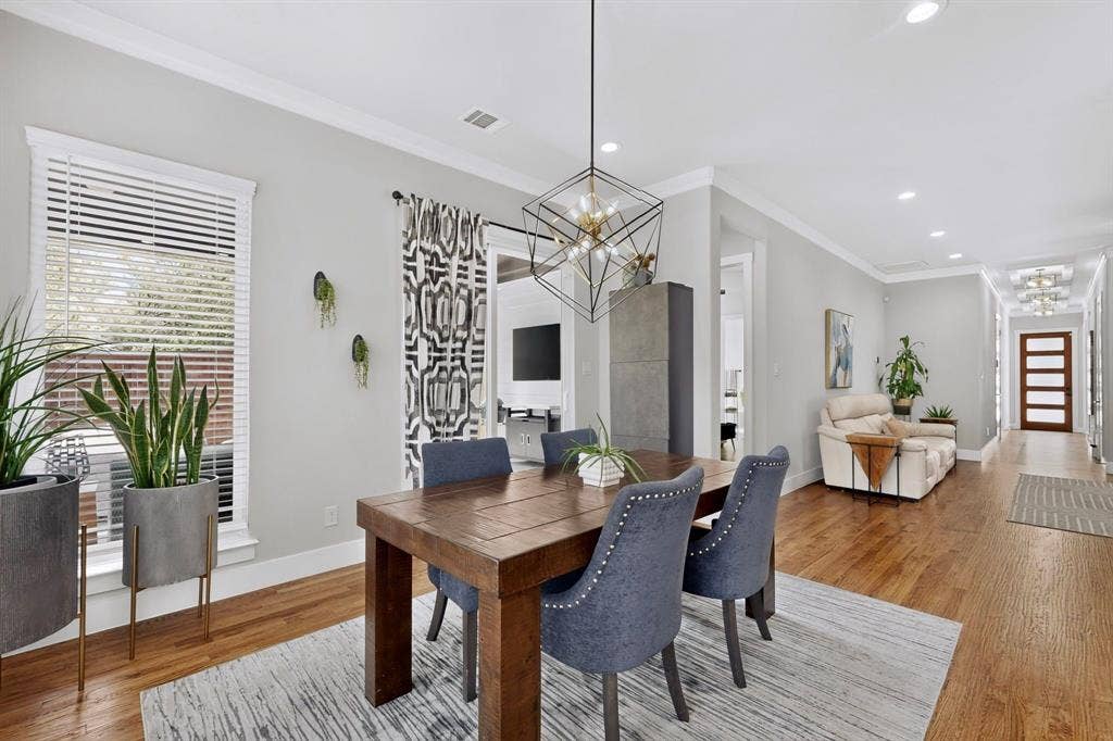 518 Crete Street, Dallas, TX 75203 Hardwood flooring, recessed lighting, crown molding, a decorative chandelier, and a wood entry door with frosted glass panels