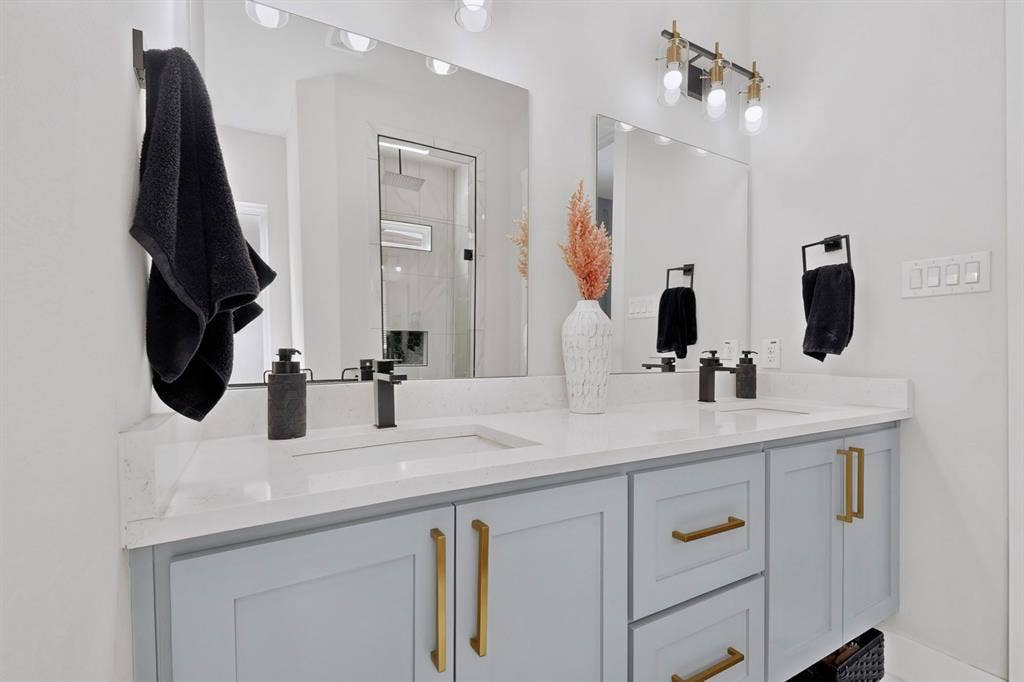 518 Crete Street, Dallas, TX 75203 Dual vanity with light gray cabinetry, gold-tone hardware, and white countertops