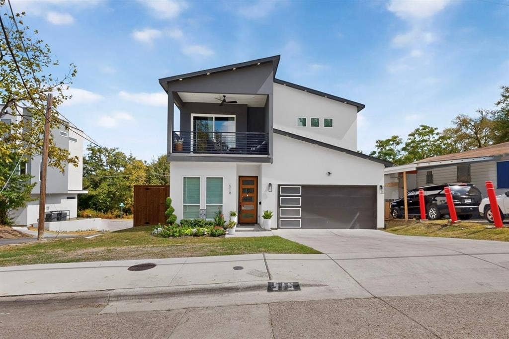 518 Crete Street, Dallas, TX 75203 Contemporary two-story exterior with a cantilevered balcony, large sliding glass doors, and an attached two-car garage with frosted panel inserts
