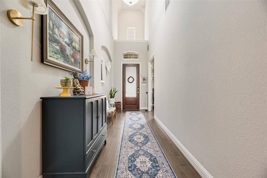 718 Waterbrook Parkway, Argyle, TX 76226 Entryway featuring wood-finish flooring, high ceilings, a transom window, and an arched doorway