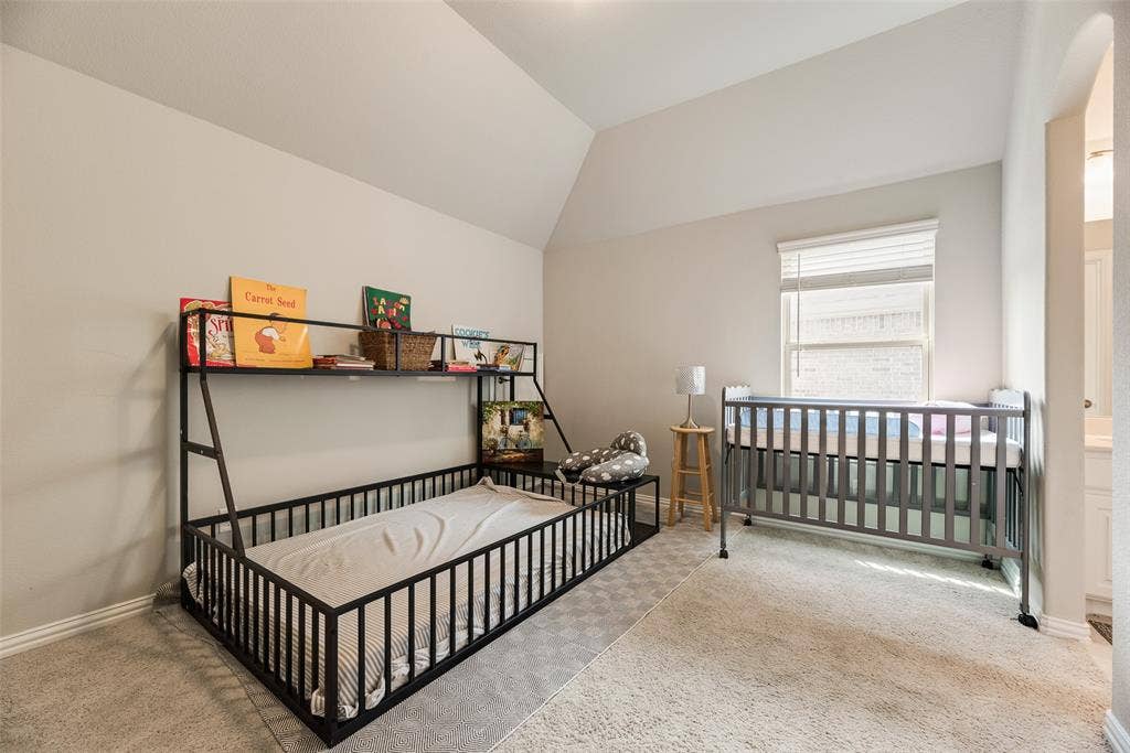 718 Waterbrook Parkway, Argyle, TX 76226 Bright and spacious bedroom suite featuring vaulted ceilings, abundant natural light from a large window, neutral wall finishes, and carpeted flooring