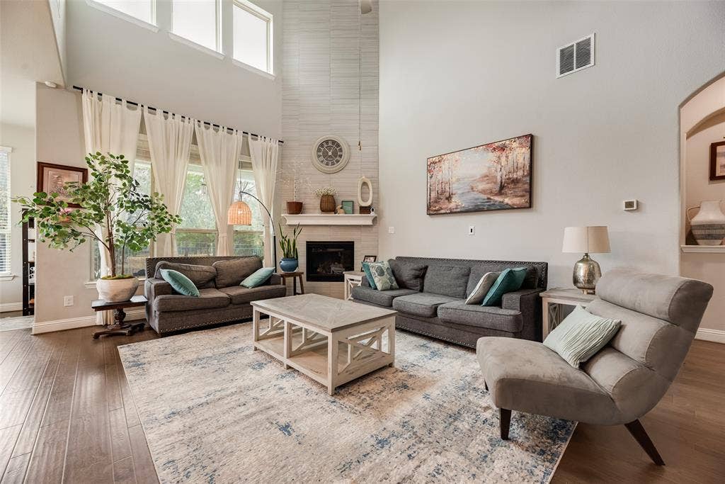 718 Waterbrook Parkway, Argyle, TX 76226 Vaulted ceiling, wood-finish flooring, fireplace with white mantel, upper transom windows, and arched doorway
