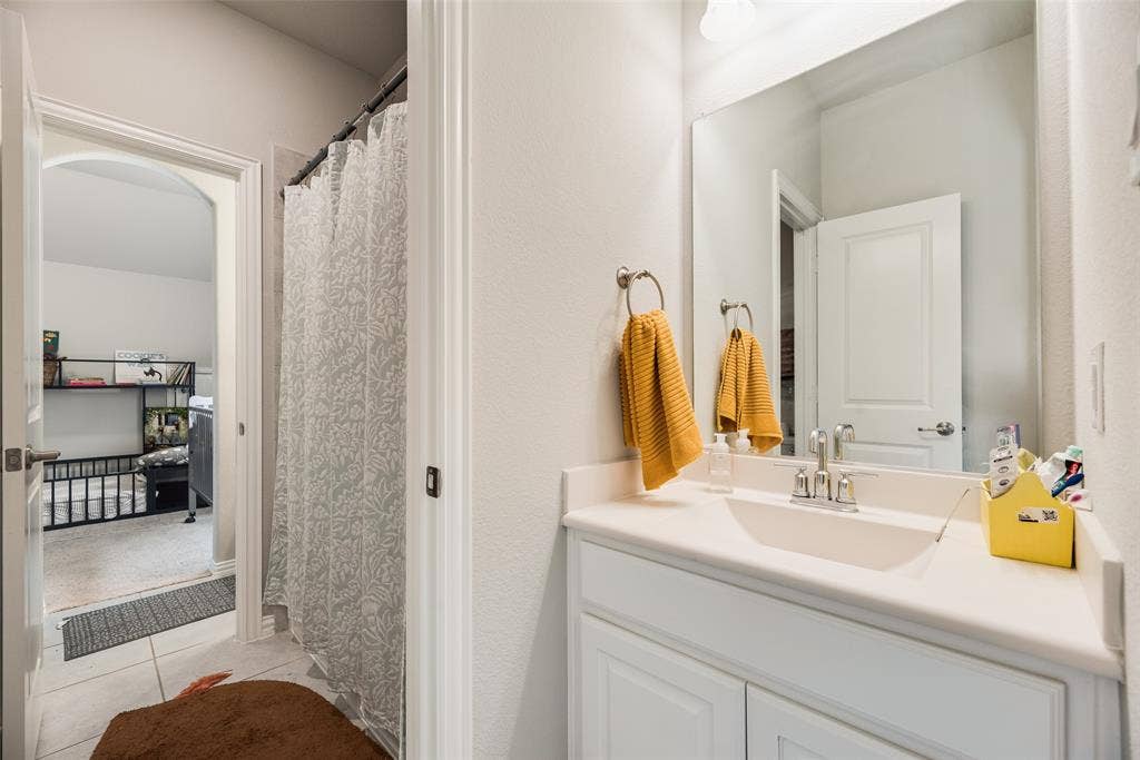 718 Waterbrook Parkway, Argyle, TX 76226 Bathroom featuring a single vanity, a polished chrome faucet, and a large wall-mounted mirror