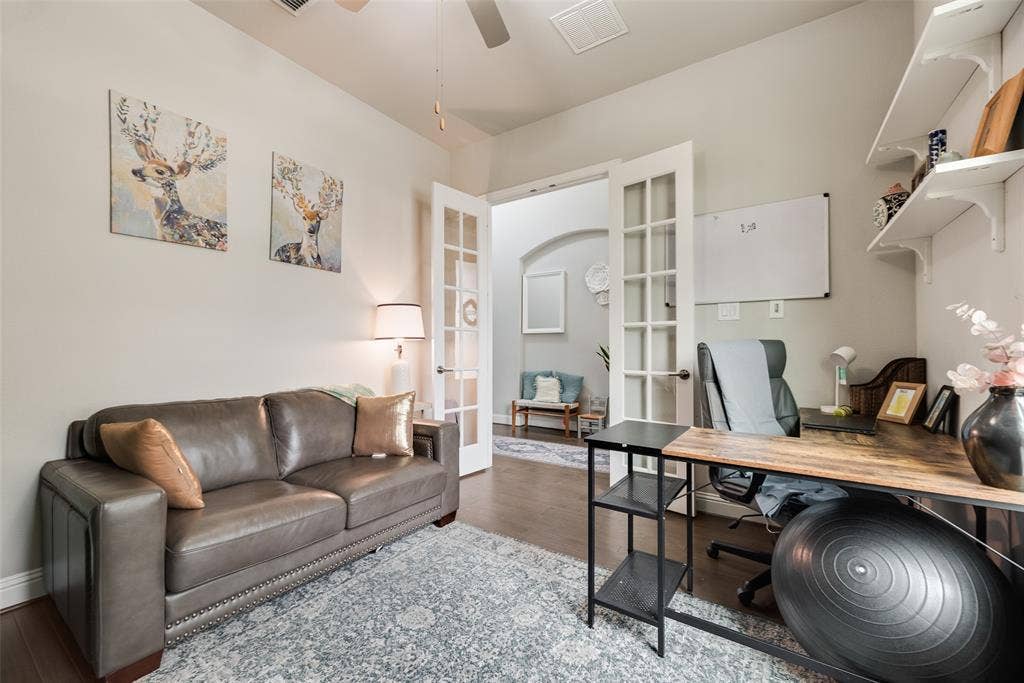 718 Waterbrook Parkway, Argyle, TX 76226 French doors with glass paneling, overhead ceiling fan, wood-finish flooring, built-in wall shelving, and an arched entry