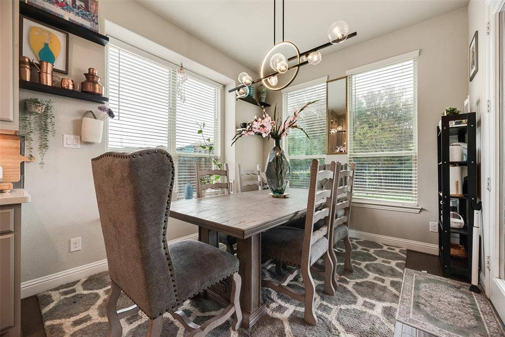 718 Waterbrook Parkway, Argyle, TX 76226 Dining area featuring a contemporary chandelier, multiple windows with blinds, built-in shelving, and wood-finish flooring