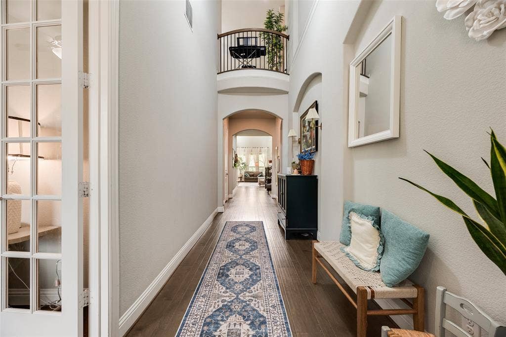 718 Waterbrook Parkway, Argyle, TX 76226 Double-height foyer featuring wood-finish flooring, an arched entryway, and a balcony with an ornate railing