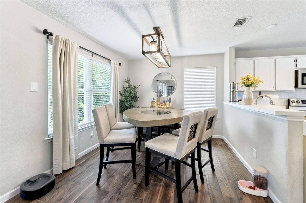 Wood-finish flooring, recessed lighting, and a linear pendant light fixture