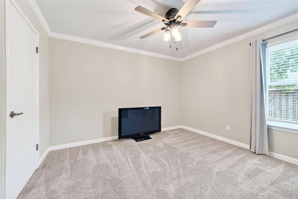 Neutral wall paint, ceiling fan with integrated lighting, window with blinds, and light-toned carpeting