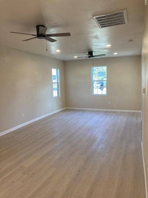 608 Turner Street, Waco, TX 76704 Expansive room featuring wood-finish flooring, two ceiling fans, recessed lighting, and multiple windows