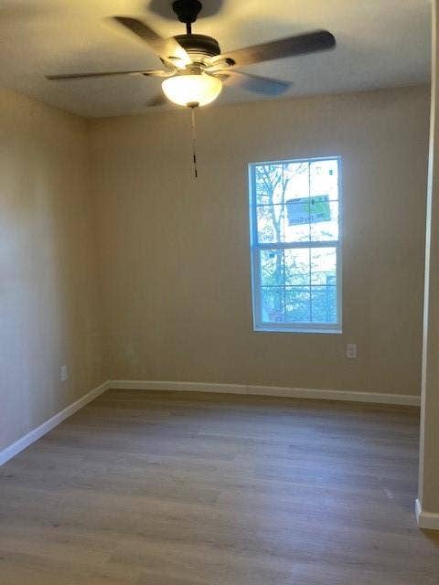 608 Turner Street, Waco, TX 76704 Wood-finish flooring, neutral wall tones, white trim, window, and a ceiling fan with integrated lighting