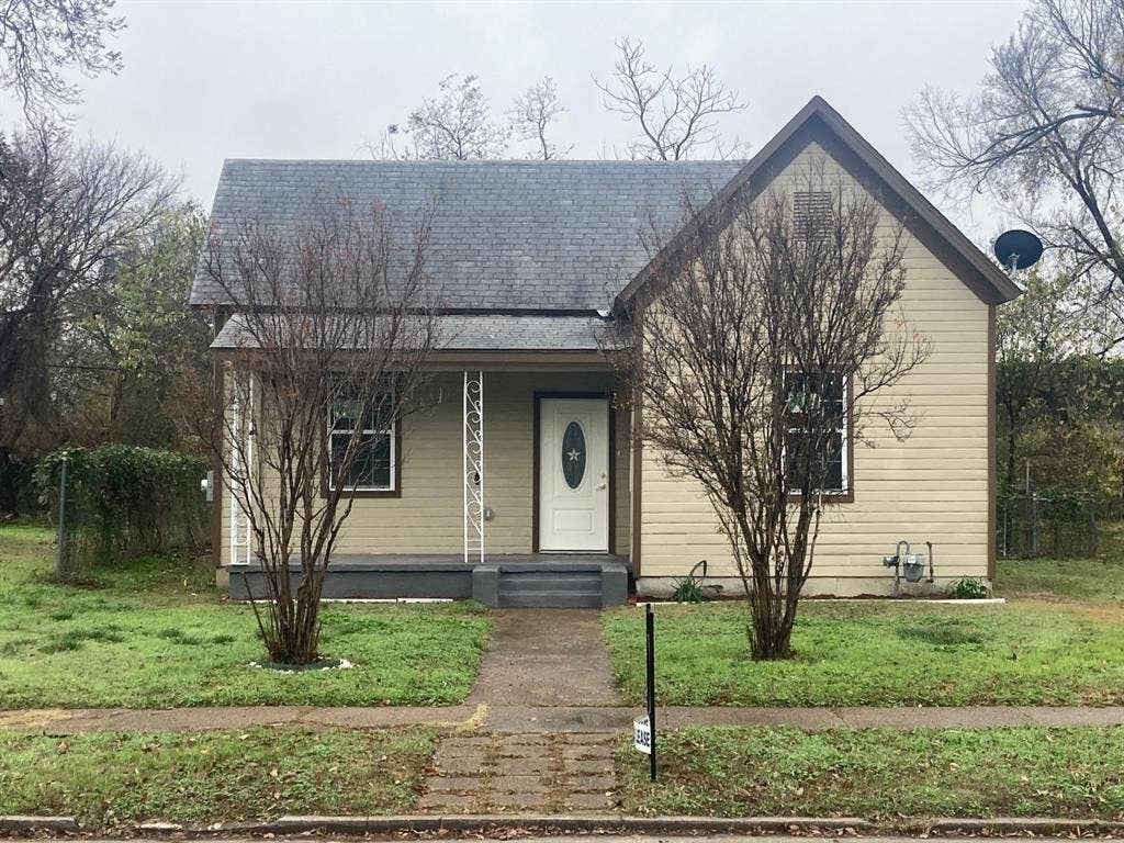 608 Turner Street, Waco, TX 76704 Single-story residence featuring light-colored siding, a dark-toned gable roof, and a front porch with decorative white columns