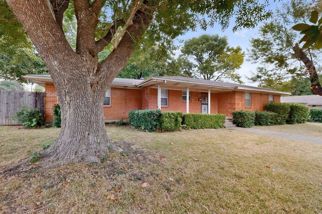 101 Spinner Circle, DeSoto, TX 75115 Brick exterior residence featuring a covered front entry, mature tree, and established landscaping