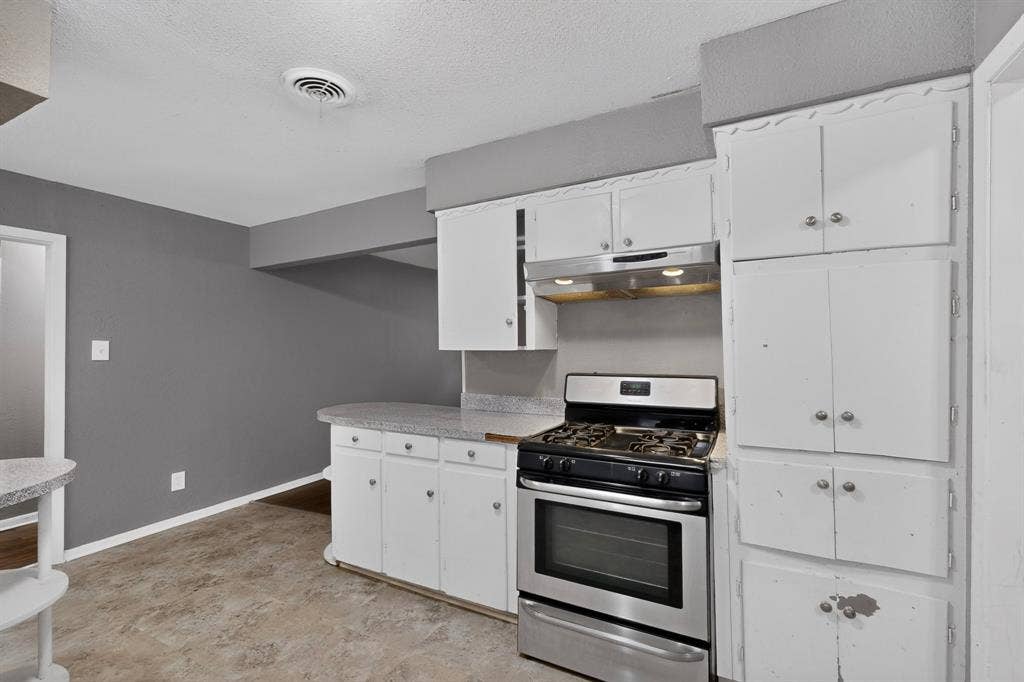 101 Spinner Circle, DeSoto, TX 75115 Kitchen featuring white cabinetry with ample storage, stainless steel gas range with convection oven, and tile flooring throughout the space