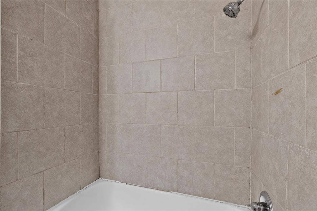 101 Spinner Circle, DeSoto, TX 75115 White bathtub with a chrome showerhead and control