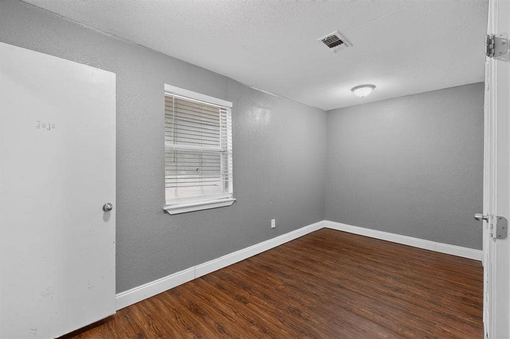 101 Spinner Circle, DeSoto, TX 75115 Wood-finish flooring, neutral gray walls, window with blinds, ceiling-mounted light fixture