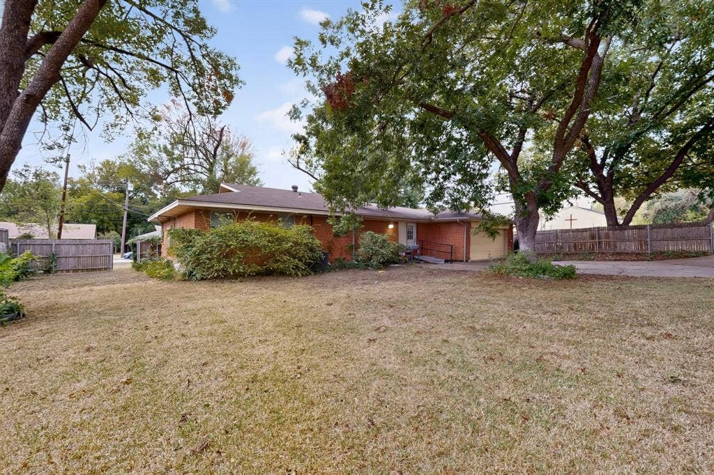 101 Spinner Circle, DeSoto, TX 75115 Expansive front lawn with mature trees and a brick exterior residence