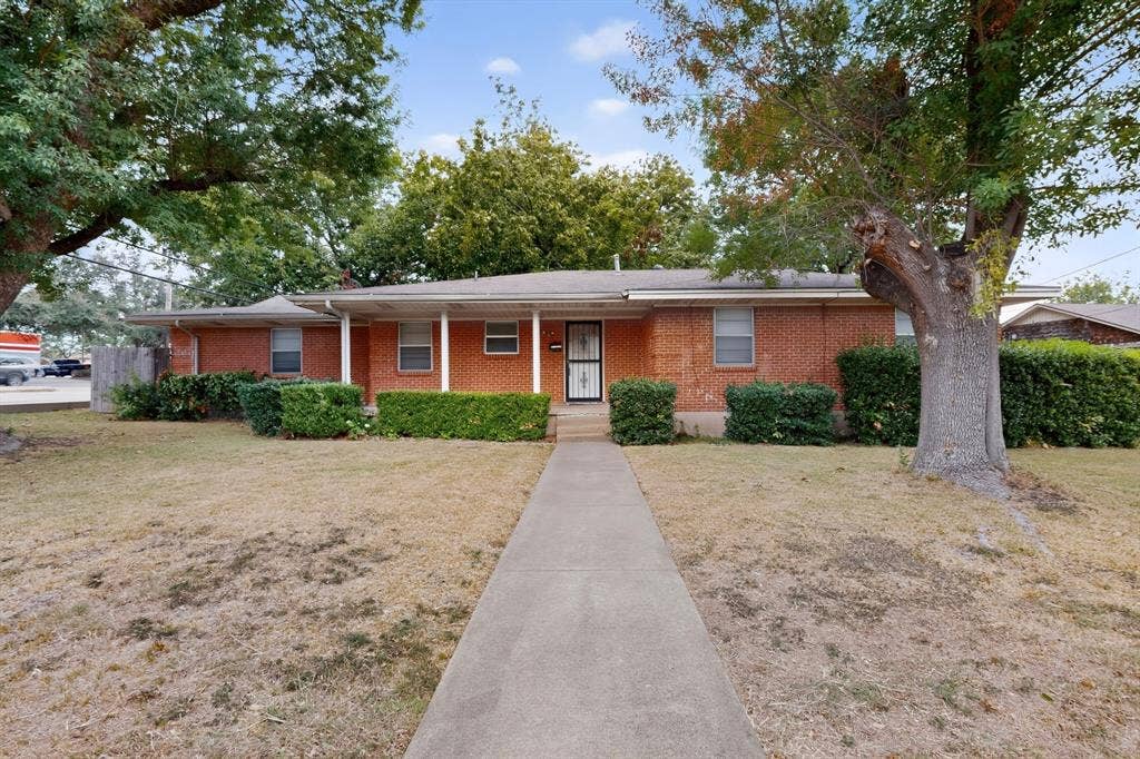 101 Spinner Circle, DeSoto, TX 75115 Brick exterior with a covered porch, mature trees, and a concrete pathway
