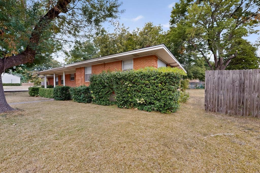 101 Spinner Circle, DeSoto, TX 75115 Brick exterior, covered front porch, established landscaping, and a wooden privacy fence